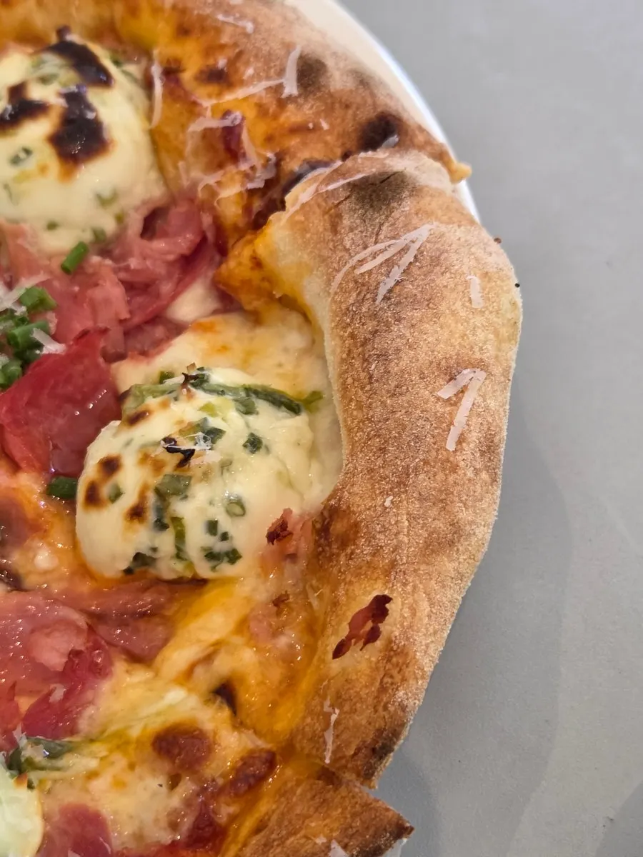 A cut slice of the Pemanong Jambon Pizza