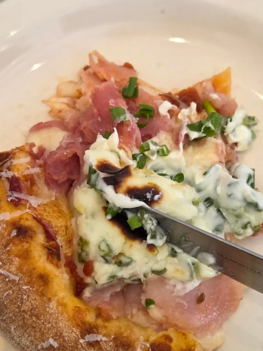 A pizza slice combining cream cheese and jambon