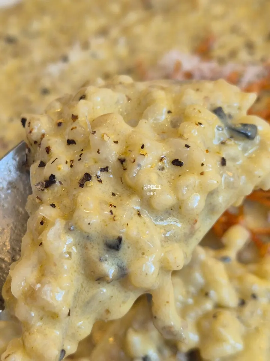 A spoonful of abalone cream risotto lifted up