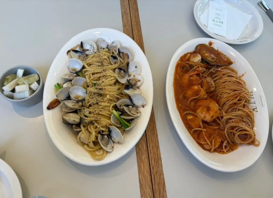Vongole and tomato pasta placed together on the table