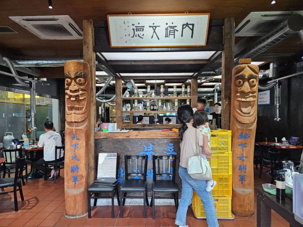 Restaurant entrance with wooden statues on either side of the counter