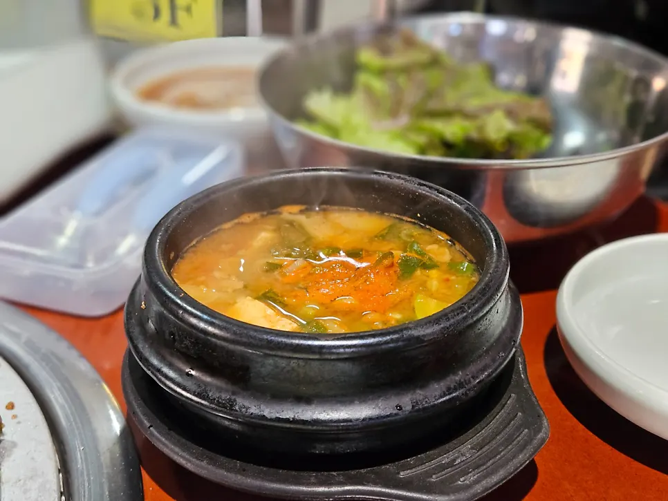 Doenjang jjigae with tofu and zucchini alongside a bowl of rice