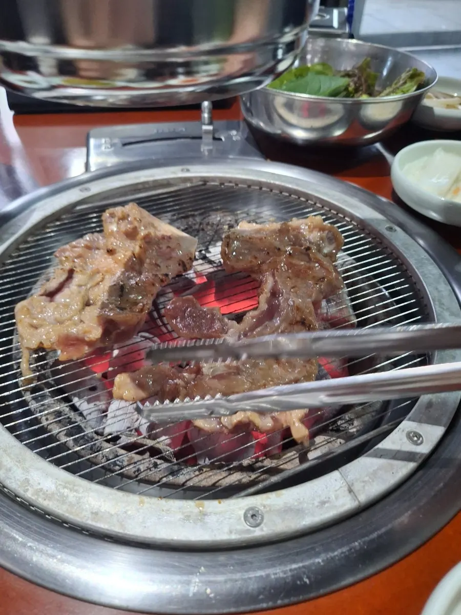 불판 위 갈비를 뒤집는 모습