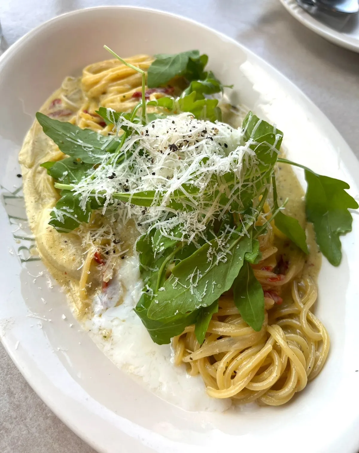 Basil pesto cream pasta served at the table