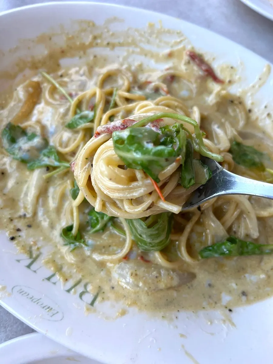 Poached egg topped with basil and cheese in cream sauce