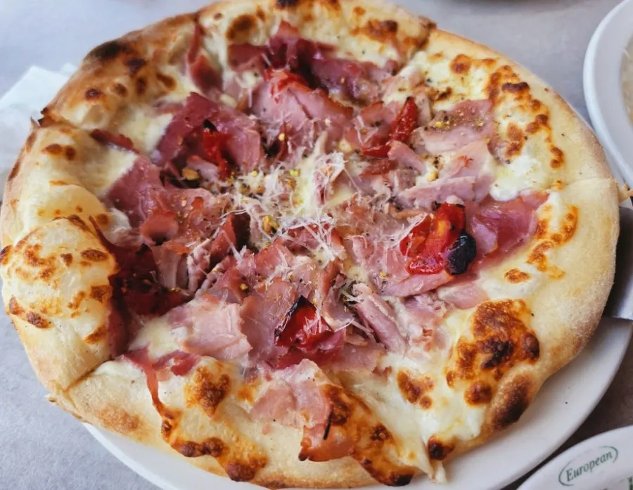 A warm slice of jambon pizza