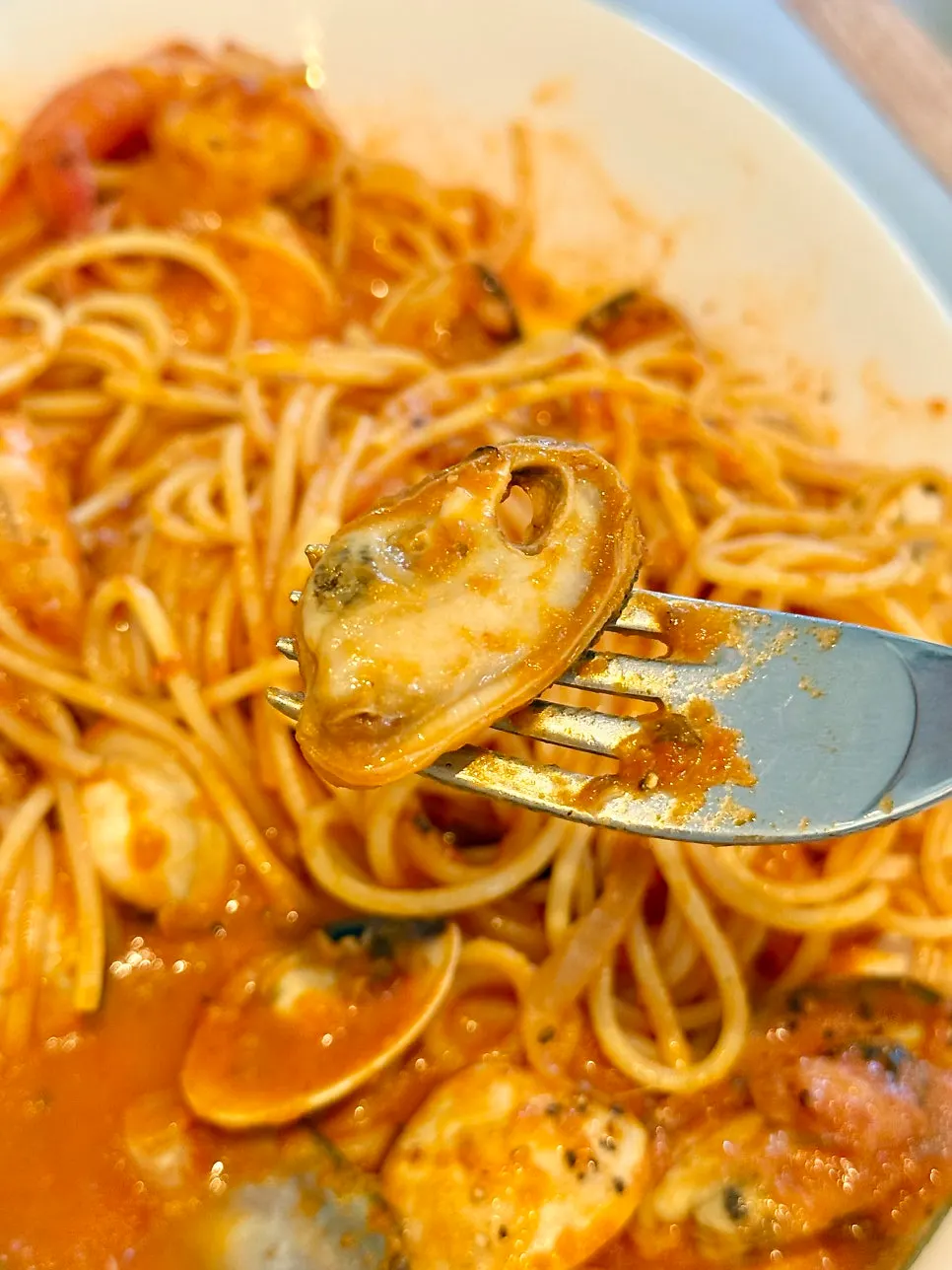Seafood tomato pasta twirled onto a fork
