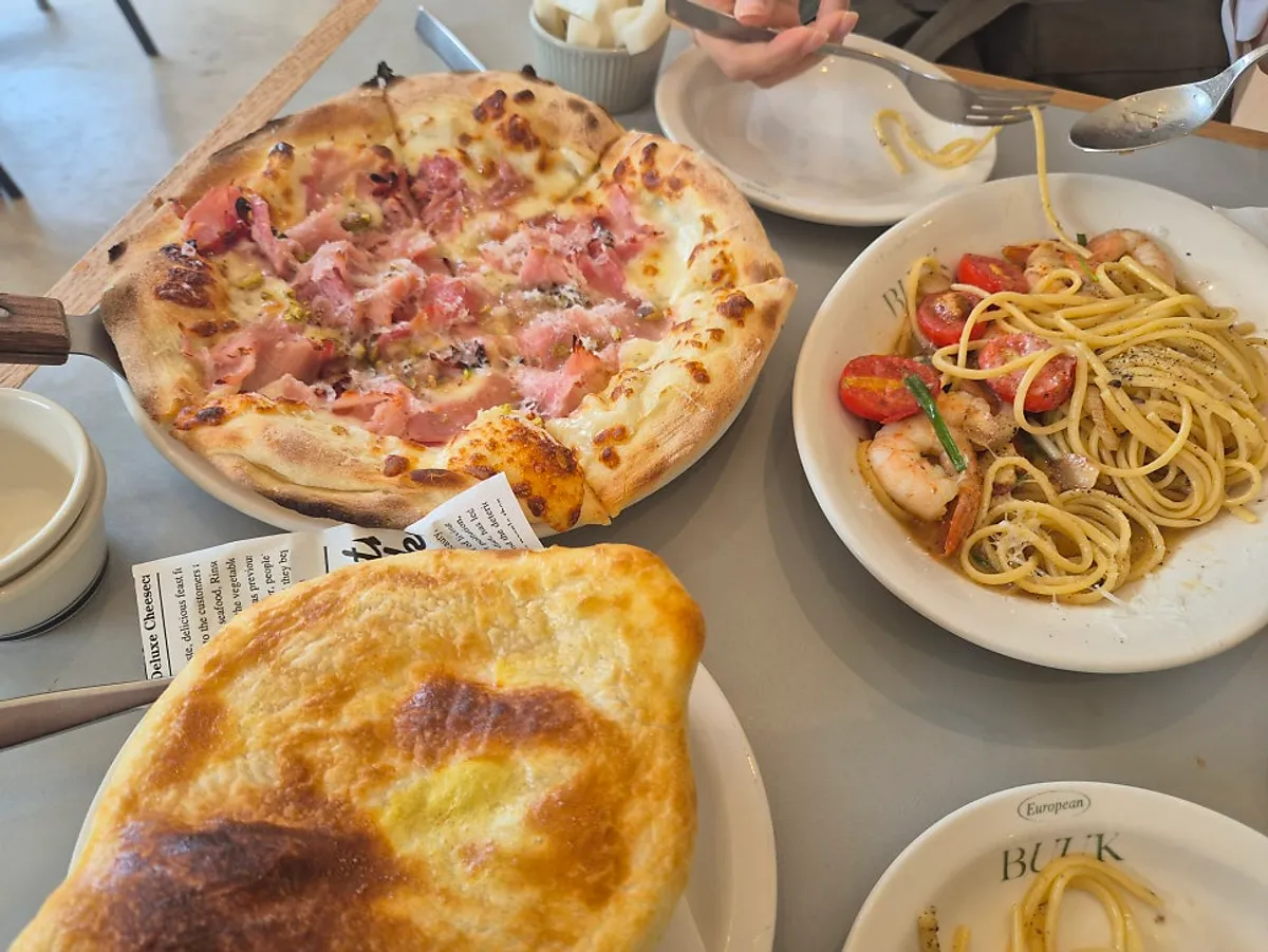 Soup, pasta and pizza all together on the table at Bueokgan Suwan Branch