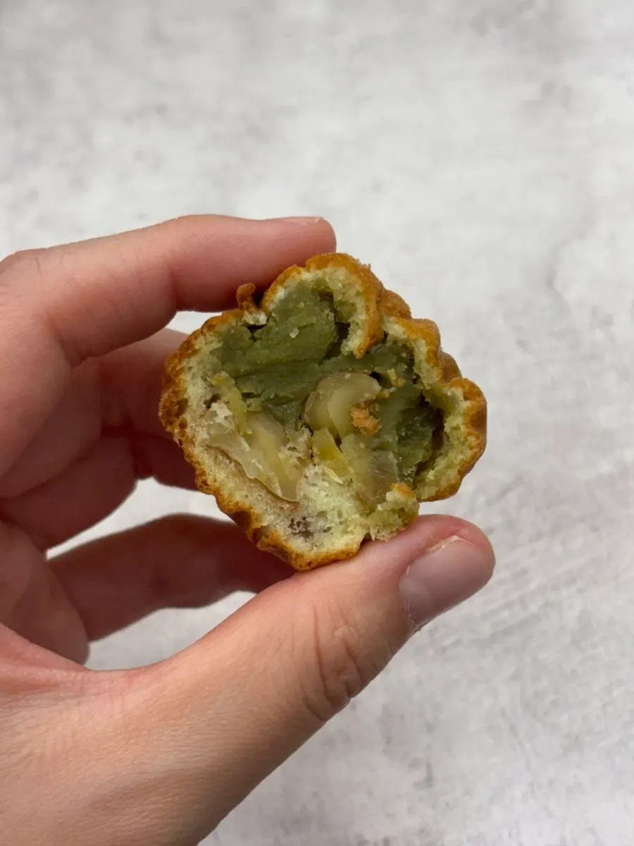 Cross-section of a walnut pastry with layered green pea paste and cream cheese