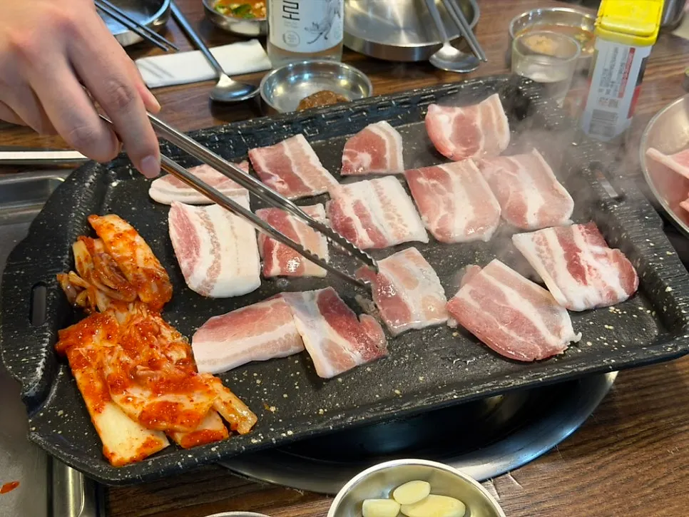 노릇하게 구워진 냉삼과 함께 익는 김치