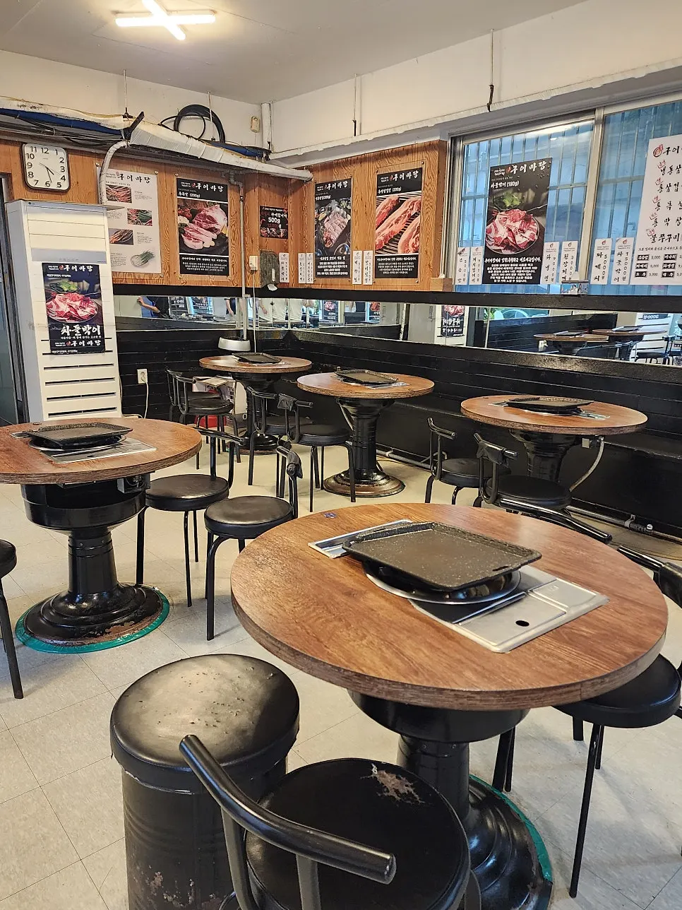 Korean barbecue space with round tables and chairs