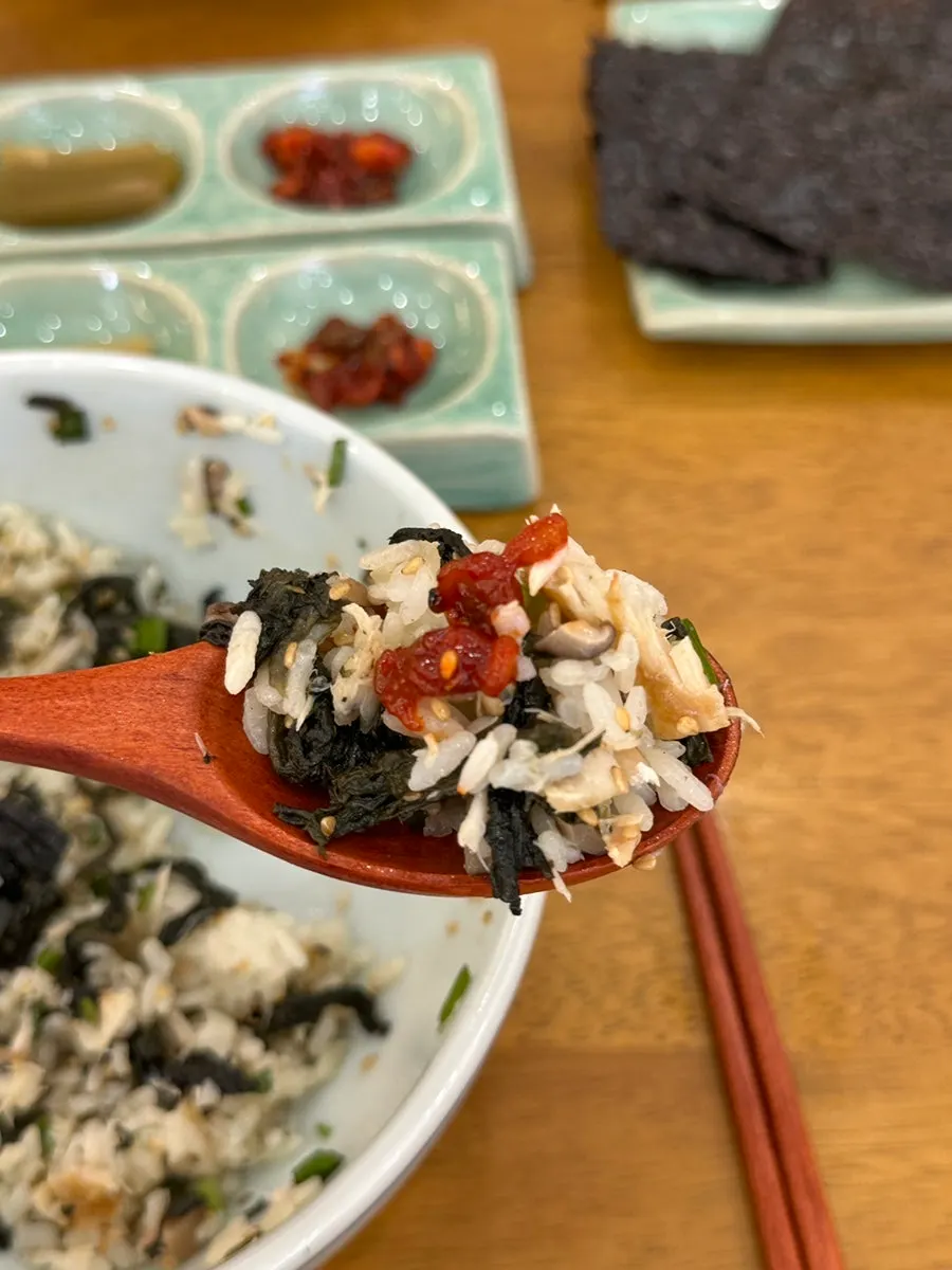 A bite of gondre rice topped with bibim jeotgal