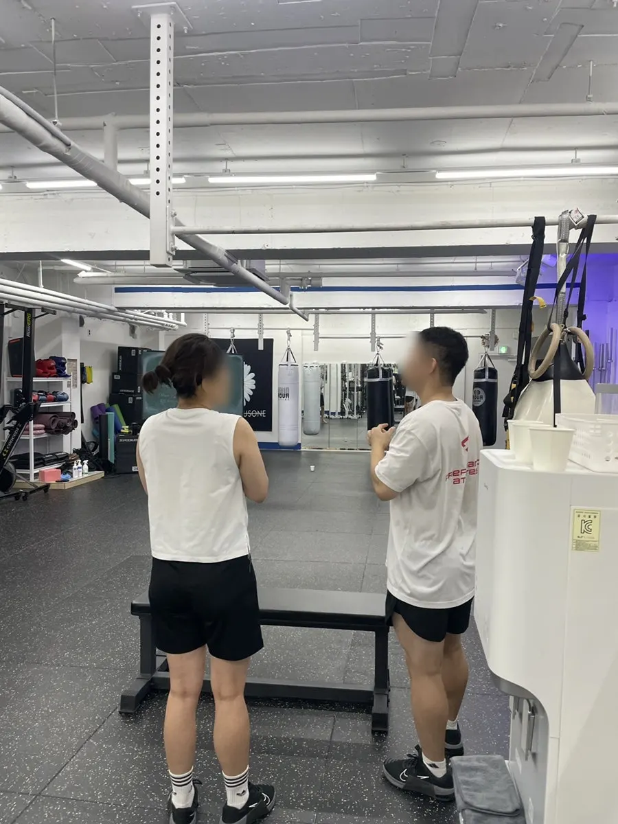 코치의 자세 교정을 받는 그룹PT 회원