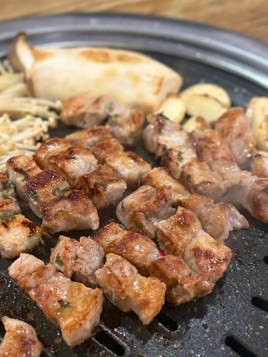 切れ目を入れた国産生サムギョプサルを焼く様子