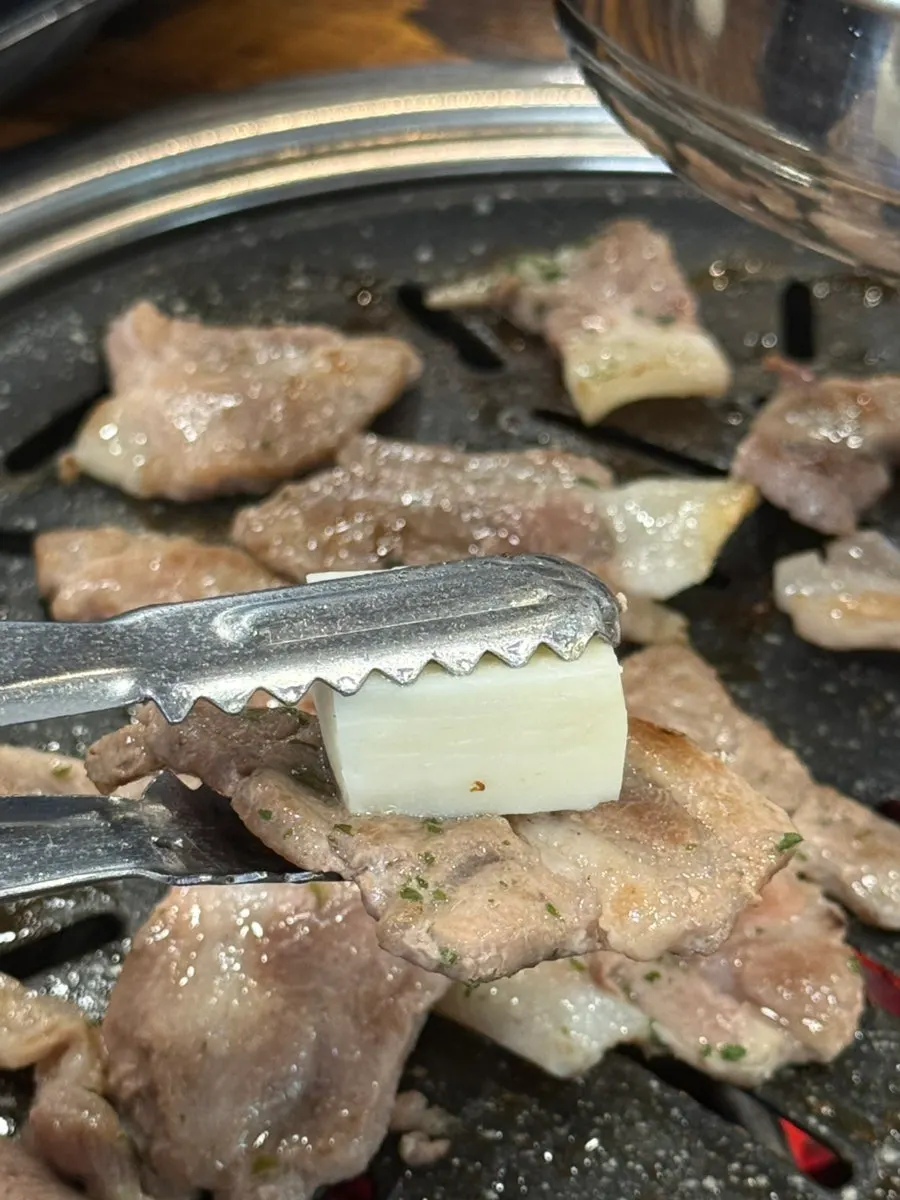 A piece of kkodeulsal eaten with cheese