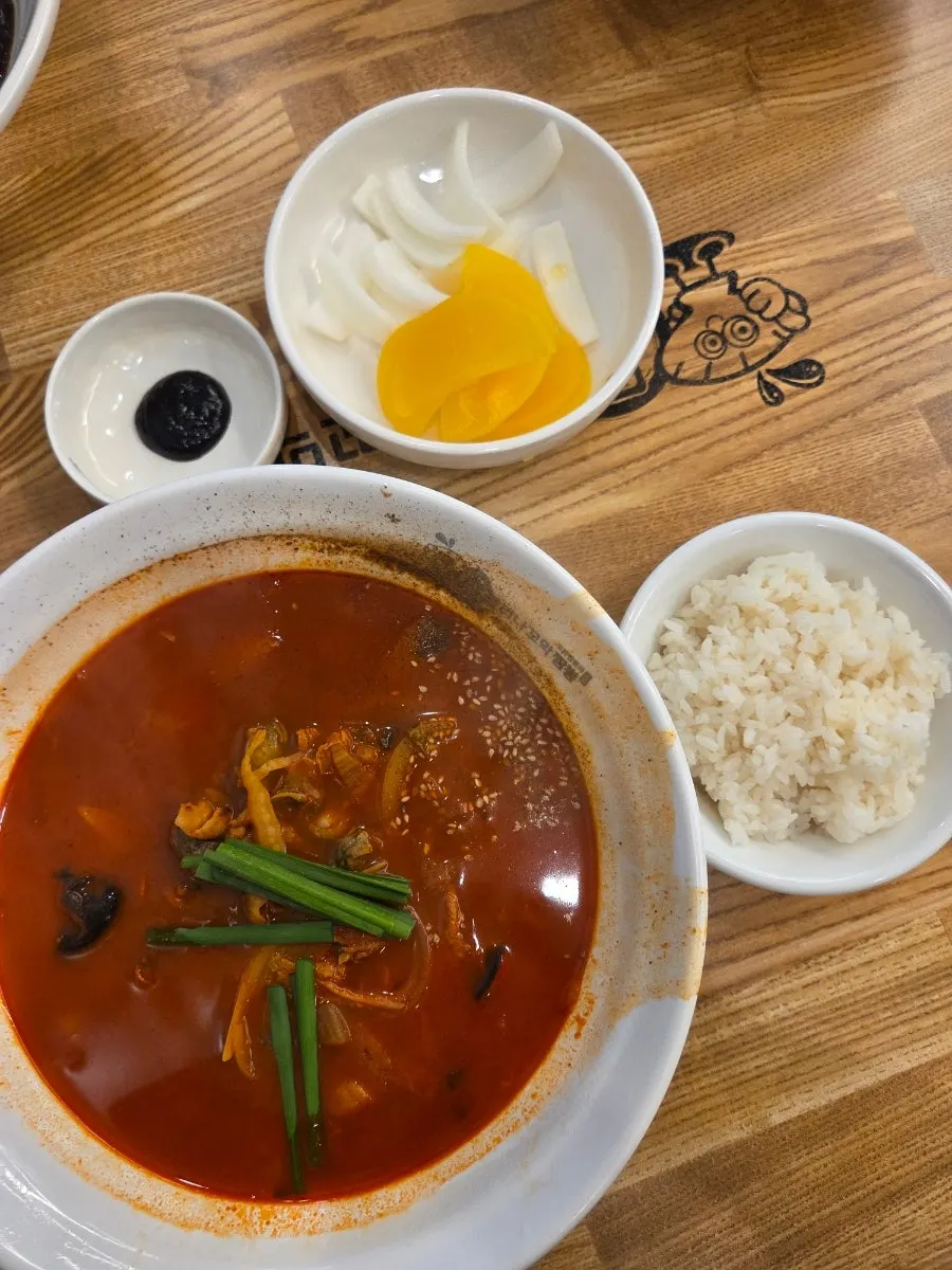 A bowl of cockle jjamppong rice in red broth