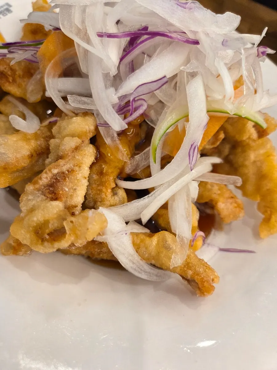 Small sweet and sour pork topped with onions