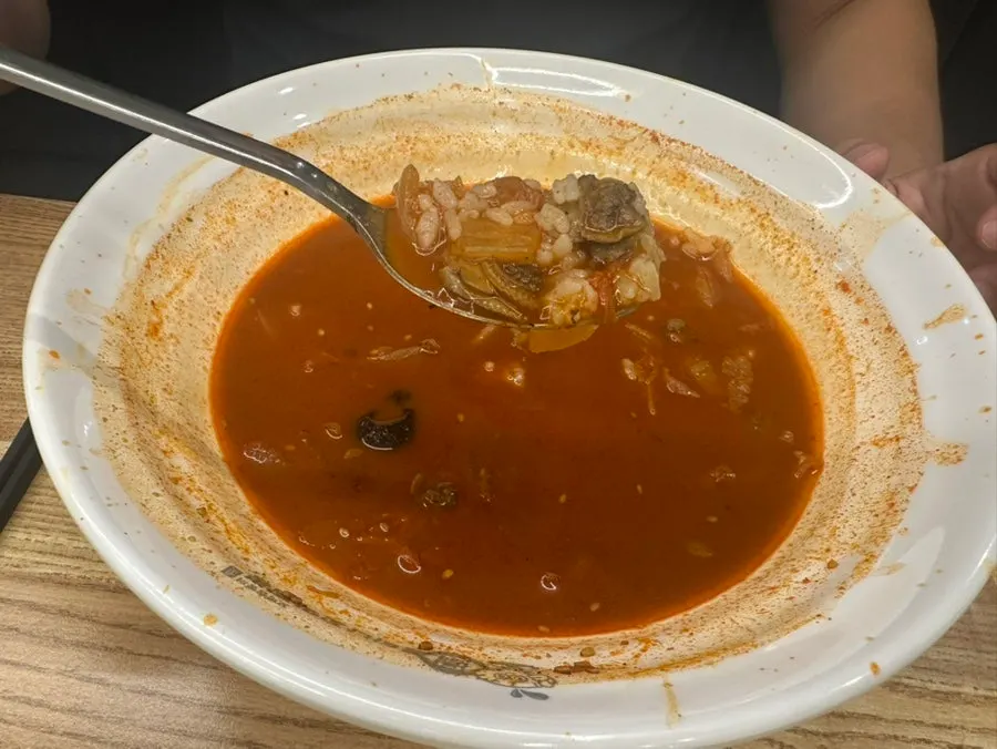 A bowl of steamed rice next to the jjamppong broth
