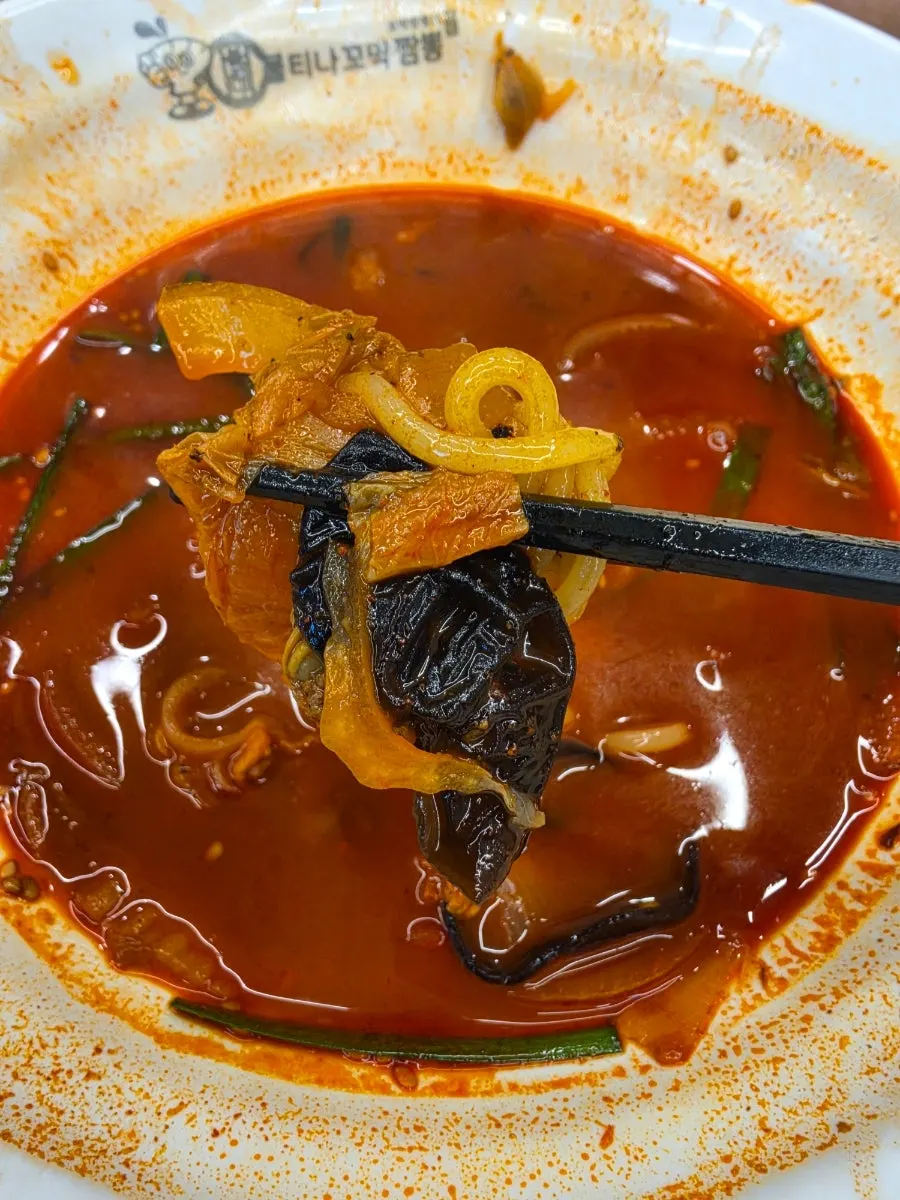 젓가락으로 들어올린 꼬막짬뽕 면