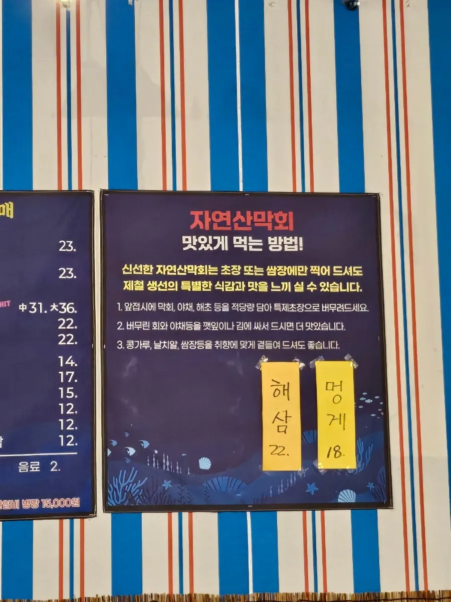 Interior of the restaurant with a sign listing the raw fish varieties