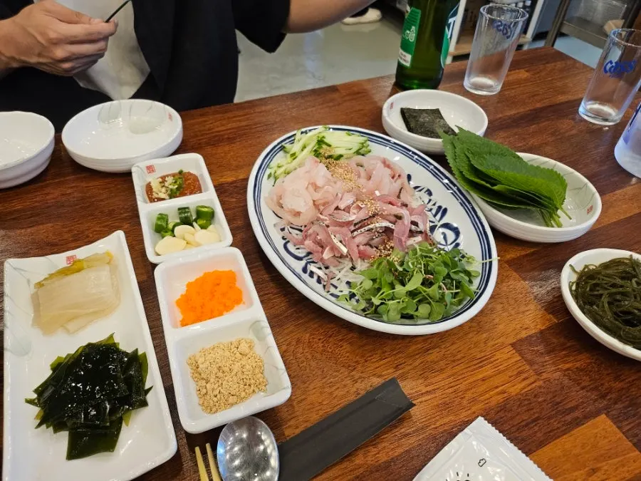Mixing the makhoe with cucumber, sprouts, and shredded radish