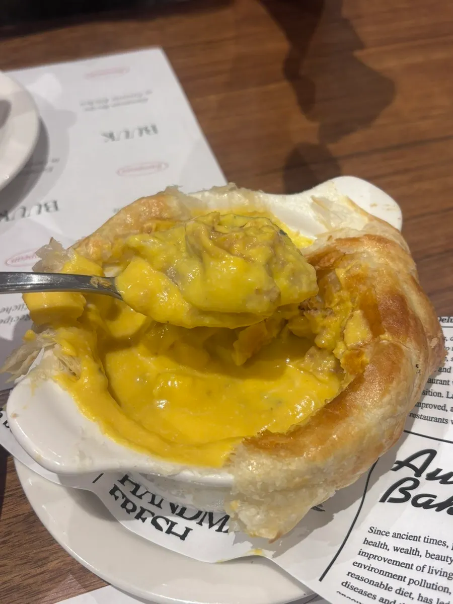Pastry dipped into the pumpkin soup