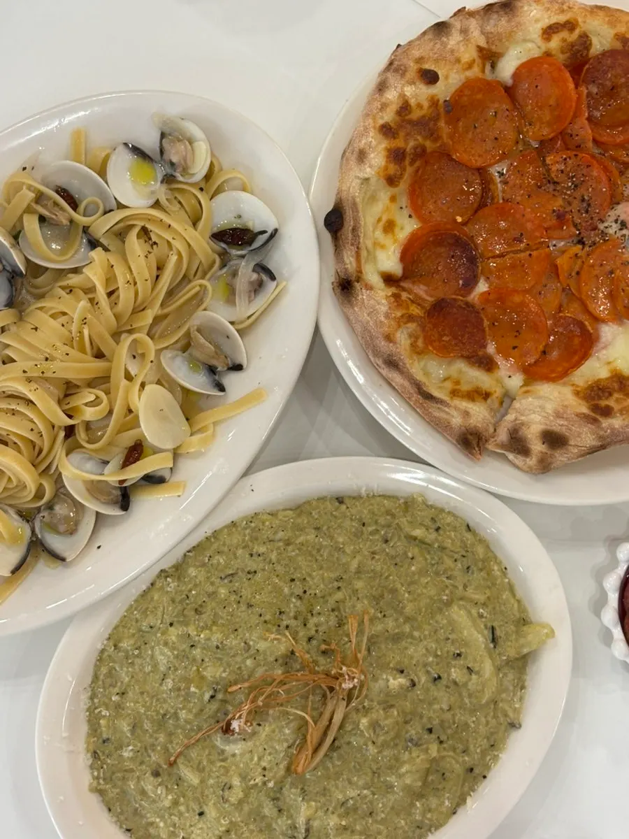 Mesa servida con pasta, risotto y pizza al mismo tiempo