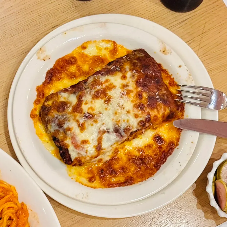 A bite of lasagna topped with plenty of meat sauce