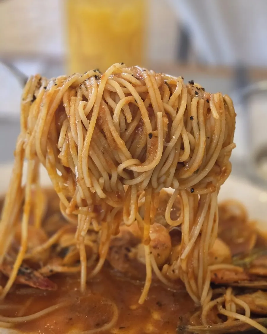 Close-up of pasta noodles coated in tomato sauce
