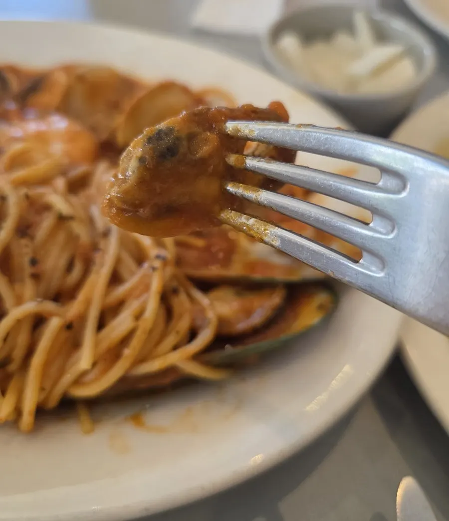 Seafood tomato pasta twirled on a fork