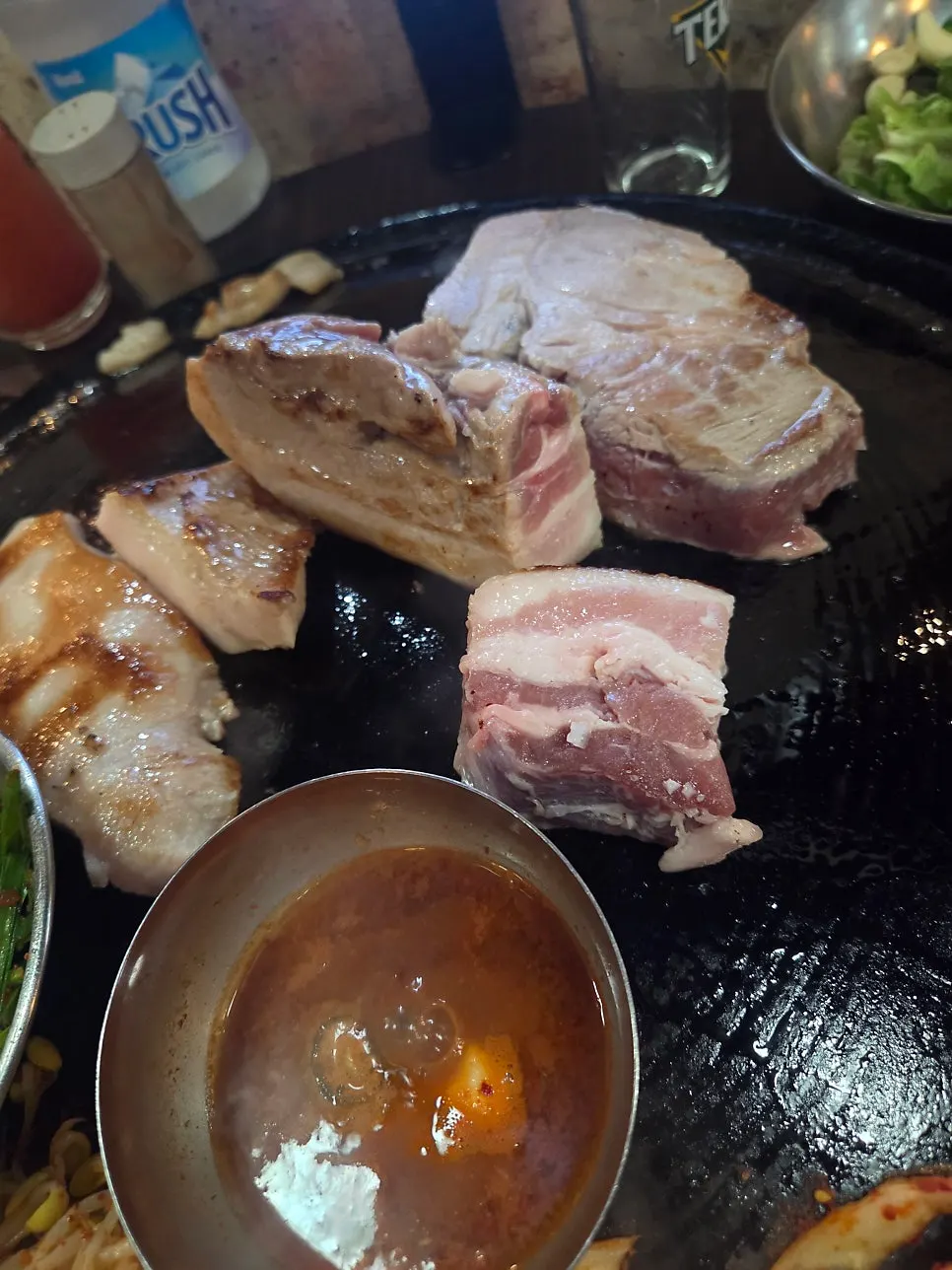 솥뚜껑 불판에 올려진 두툼한 통삼겹