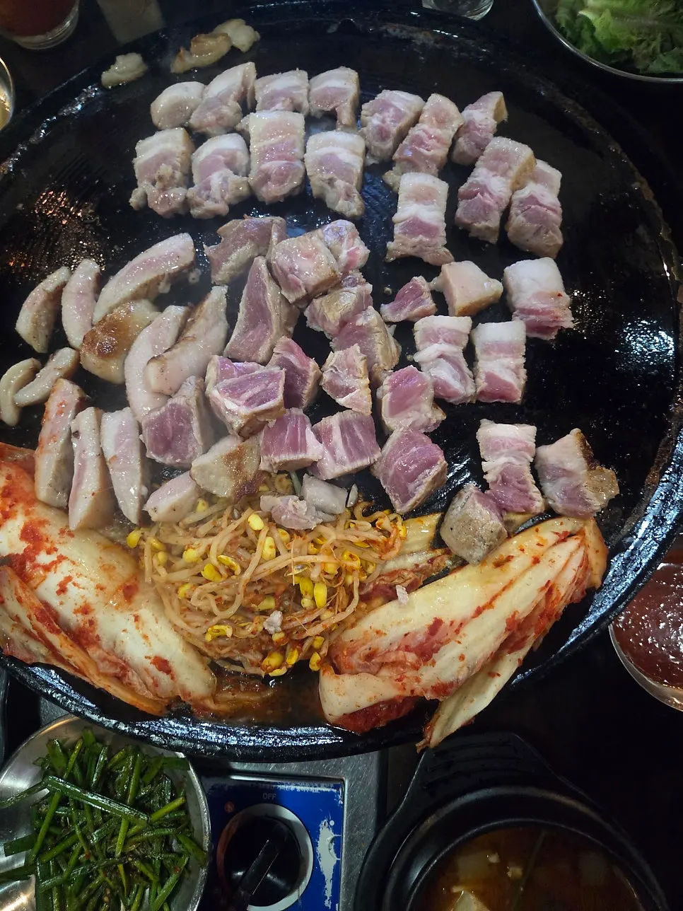먹기 좋게 커팅된 고기와 노릇하게 익은 김치, 가운데 끓는 멜젓