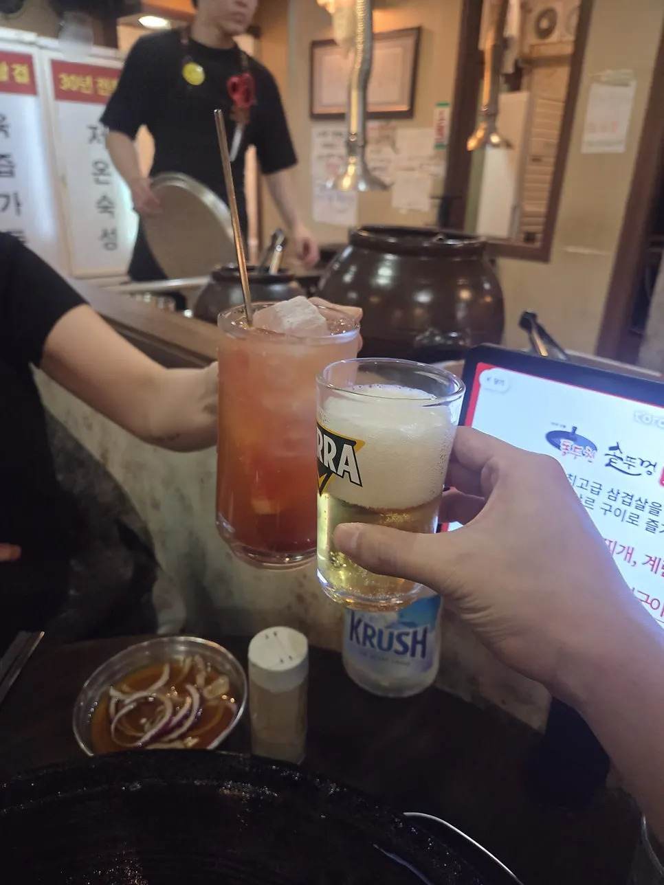 솥뚜껑 고기 앞에 놓인 동두천 하이볼과 테라 맥주