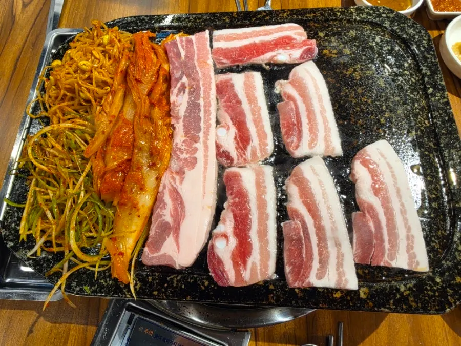 A full table of gamjatang and pork belly set dishes