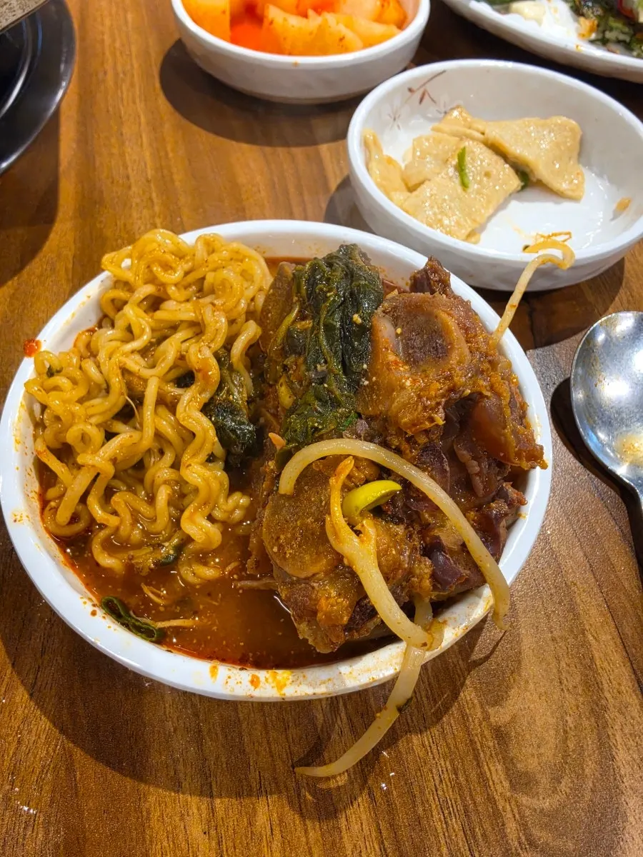 Gamjatang boiling with added ramen noodles