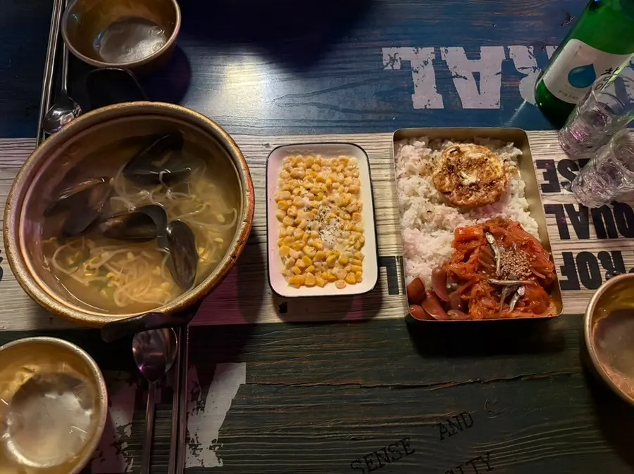 Free side dish spread with mussel bean sprout soup, corn mayo, and old-school lunchbox