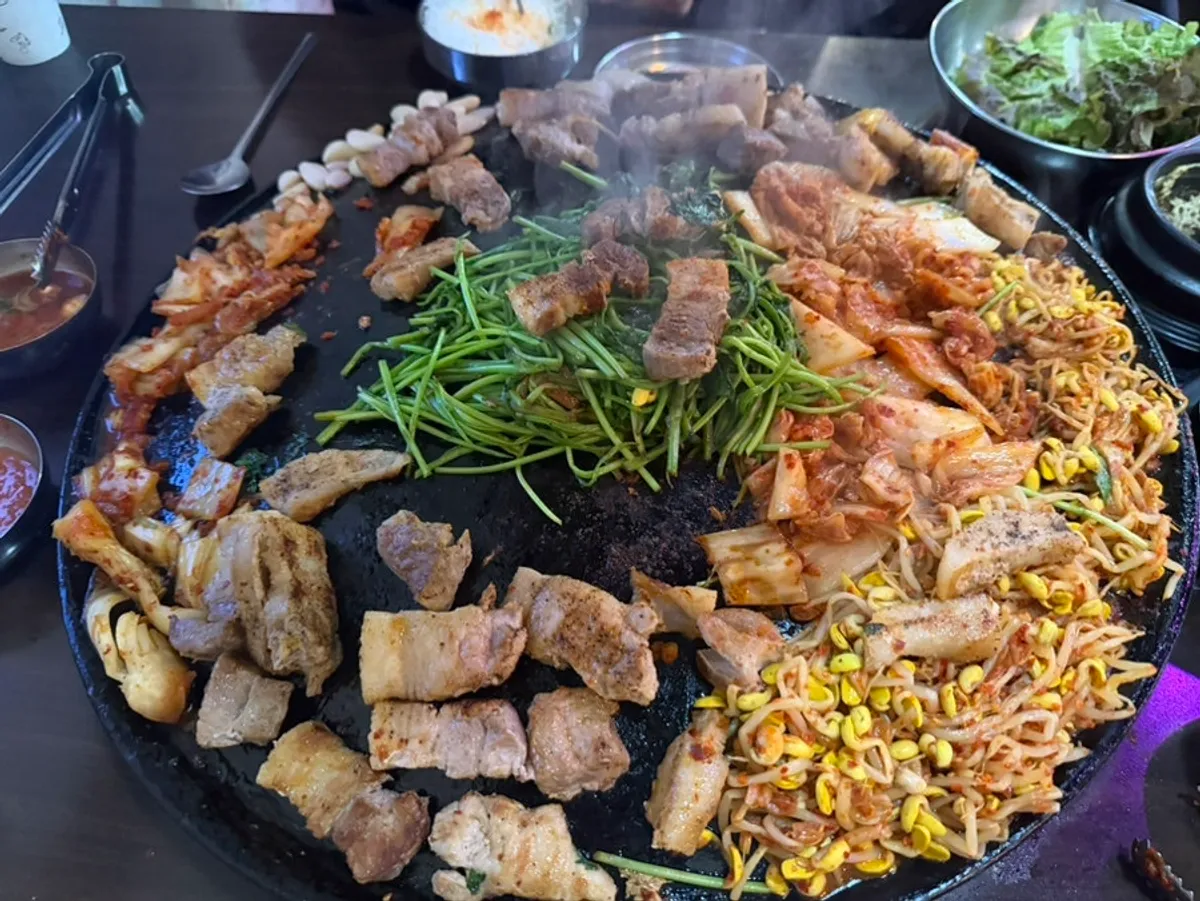 솥뚜껑 불판 위 삼겹살과 김치