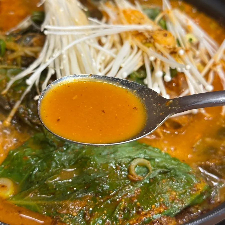 Spicy gamjatang broth simmering on the table