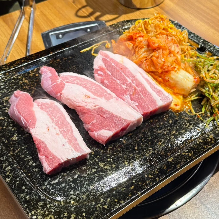 Staff member grilling the fresh pork belly