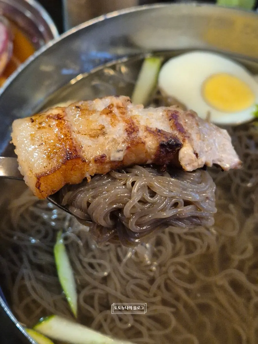 냉면 위에 삼겹살을 얹은 모습