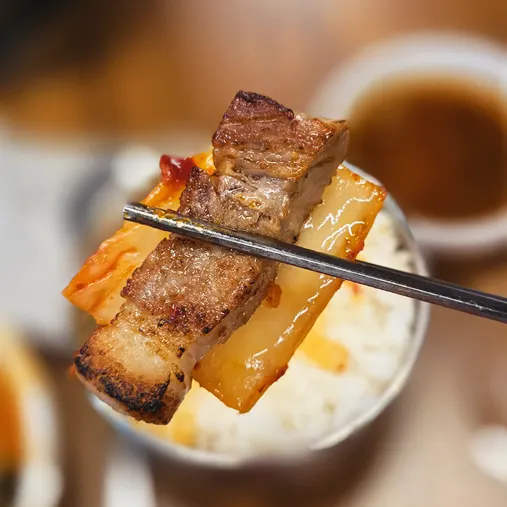 A piece of pork belly topped with bean sprouts
