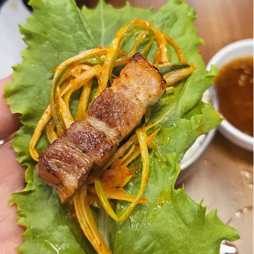 A piece of pork belly paired with grilled kimchi