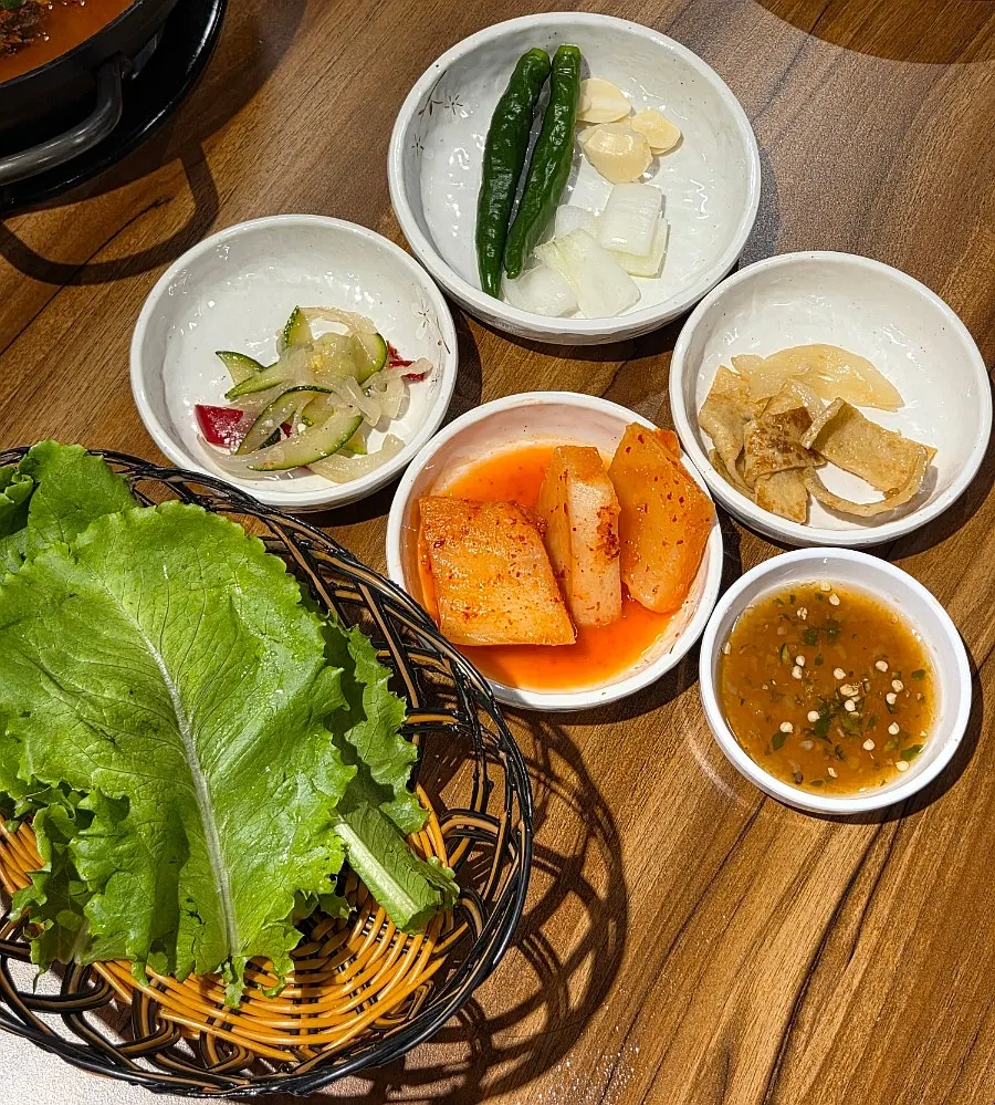 Table spread of basic side dishes including seokbakji and stir-fried fish cake