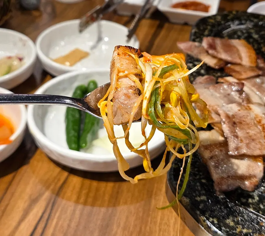 A piece of pork belly topped with side dishes
