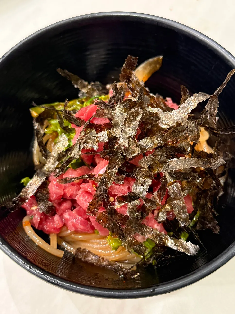 Yukhoe jjolmyeon topped with raw beef and gim powder