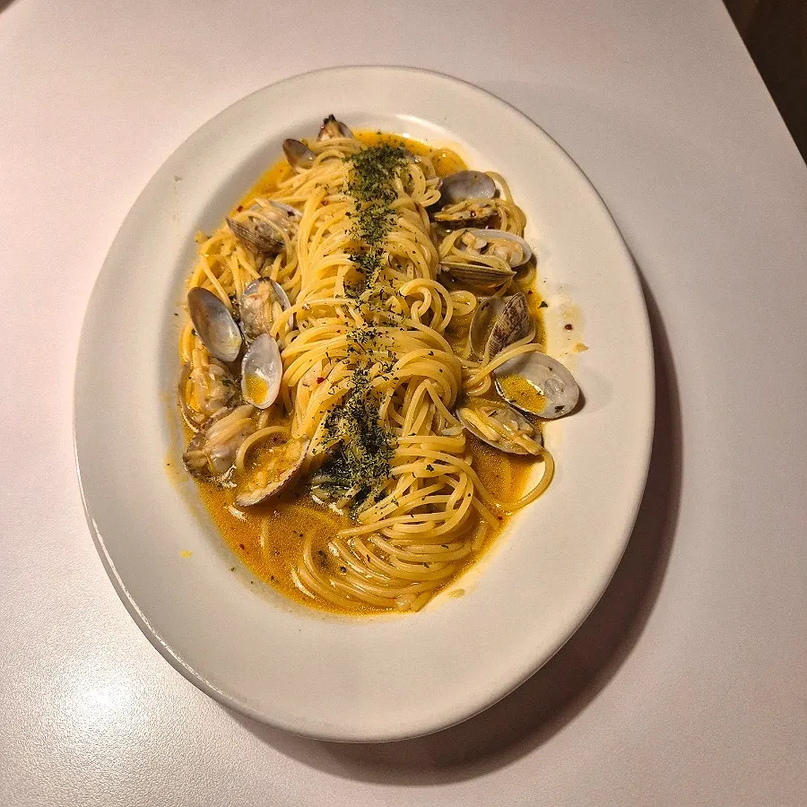 A plate of vongole pasta topped with clams