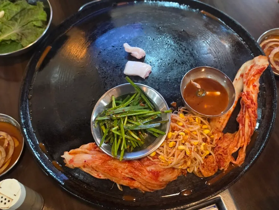 솥뚜껑 위에 올린 김치와 콩나물