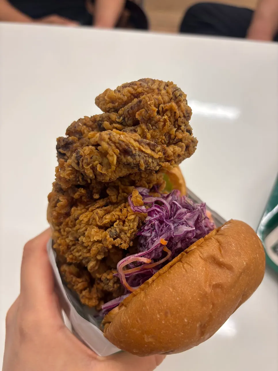 Crispy Chicken Burger patty spilling out beyond the bun