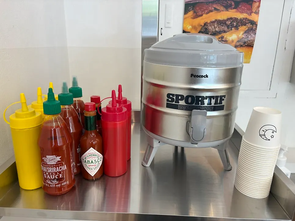 Self-serve bar with mustard, ketchup, tabasco, and sriracha