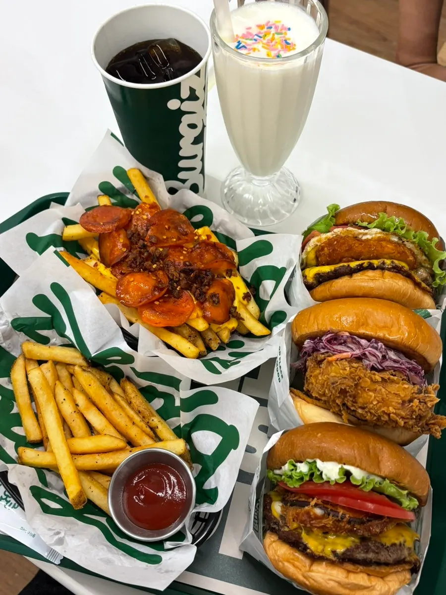 Table with three burgers and cheese fries